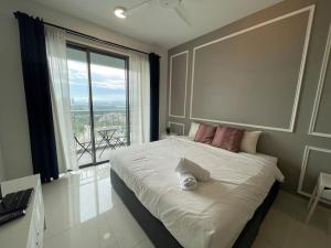 una camera da letto con un grande letto con una grande finestra di Teega Suites PuteriHarbour By WP Homestay a Johor Bahru