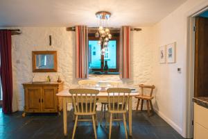 Un comedor con mesa y sillas de madera. en St Davids Hideaway with Roll-top Bath & Log Burner, en St. Davids
