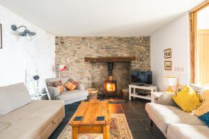 a living room with a couch and a table at St Davids Hideaway with Roll-top Bath & Log Burner in St. Davids