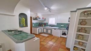 Il comprend une cuisine dotée de comptoirs blancs et de carrelage vert. dans l'établissement Mazets du Soleil, à Sainte-Maxime