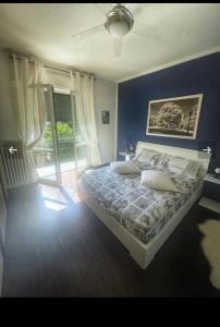 a bedroom with a bed with a blue wall at Casa di Princi in Brunate