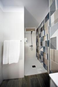 a bathroom with a shower with a white towel at Skyview Hotel Tenerife in Puerto de la Cruz