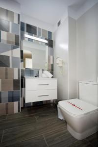 a bathroom with a white toilet and a sink at Skyview Hotel Tenerife in Puerto de la Cruz