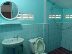 a bathroom with a sink and a toilet and a mirror at Cha Bungalow in Ko Yao Noi