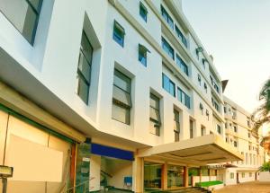 an office building with a white facade at Green Park Residency in Kannur