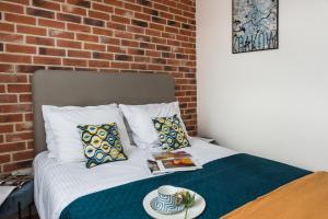 a bedroom with a bed with a brick wall at Avenue Apartment by LoftAffair in Kraków