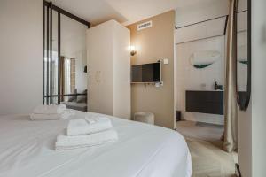 um quarto com uma cama branca e toalhas em Bens The Highdocks em Amesterdão