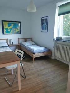 Habitación con cama, escritorio y mesa. en Gemütliche Gästewohnung in ruhiger Lage en Kronshagen
