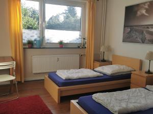Duas camas num quarto com uma janela em Gemütliche Gästewohnung in ruhiger Lage em Kronshagen