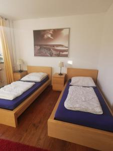 ein Schlafzimmer mit 2 Betten und einem Wandgemälde in der Unterkunft Gemütliche Gästewohnung in ruhiger Lage in Kronshagen