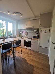 a kitchen with white appliances and a table and chairs at Gemütliche Gästewohnung in ruhiger Lage in Kronshagen