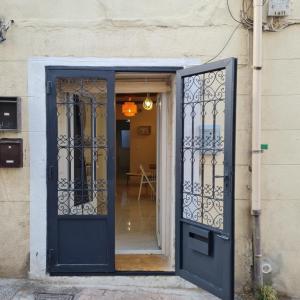 una porta blu con un cancello in ferro battuto di Sète, T2 cosy et atypique, Jardin Château d'eau, centre ville a Sète
