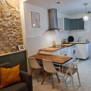 una cucina con un tavolo e sedie in legno in una stanza di Sète, T2 cosy et atypique, Jardin Château d'eau, centre ville a Sète
