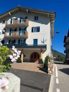a large white building with a balcony at Casa Dalsass - Appartamenti nel verde in Cavedago