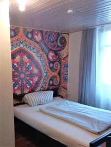 a bed in a room with a tapestry on the wall at Hotel-Restaurant-Krone in Bad Brückenau