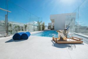 a house with a swimming pool and a bottle of wine at Sercotel Sevilla Guadalquivir Suites in Seville