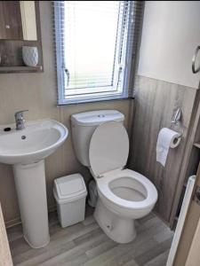 ein Bad mit einem WC und einem Waschbecken in der Unterkunft Immaculate Sen friendly 3-Bed caravan in Porthcawl in Porthcawl