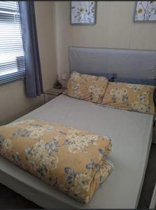 ein weißes Bett mit einer Decke darüber in der Unterkunft Immaculate Sen friendly 3-Bed caravan in Porthcawl in Porthcawl