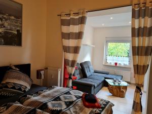 a living room with a bed and a couch at Ferienwohnung am Kurpark in Bad Rothenfelde