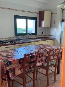 eine Küche mit einem Tisch mit Stühlen und einem Waschbecken in der Unterkunft Bounganville 127 in Alcamo Marina