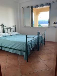 ein Bett in einem Schlafzimmer mit einem großen Fenster in der Unterkunft Bounganville 127 in Alcamo Marina