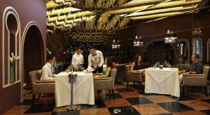 eine Gruppe von Personen, die in einem Restaurant an Tischen sitzen in der Unterkunft The Chateau Spa & Wellness Resort in Bukittinggi
