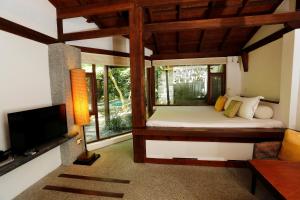 Mudanwan Villa في Mudan: غرفة نوم بسرير وتلفزيون في غرفة