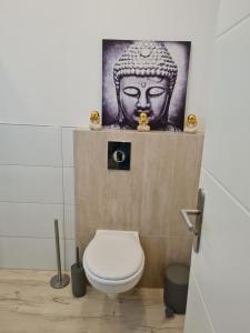 a bathroom with a toilet and a picture of a head at Ferienwohnung am Kurpark in Bad Rothenfelde