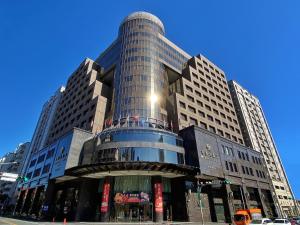 a tall glass building on a city street at Monarch Plaza Hotel in Taoyuan