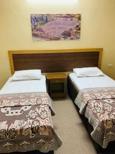 2 camas en una habitación de hotel con una foto en la pared en Asia Hotel en Amán
