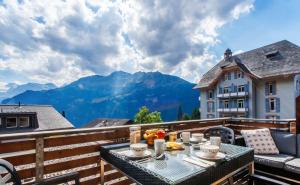 a table on a balcony with a view of mountains at Kinohaus 3 in Wengen