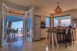 a kitchen with a island and a view of the ocean at Villa Pirogue, pieds dans l'eau in Étang-Salé