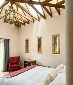 a bedroom with a bed and a red chair at The Stables - Luxury Cottage in Dumfries