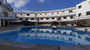 uma grande piscina em frente a um edifício em Paramount Gardens Resorts C201 em Lárnaca