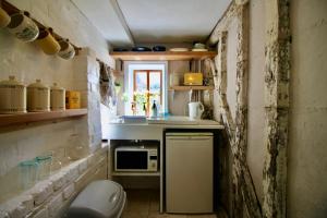 a small kitchen with a sink and a microwave at The Cottage at Barkwith House in Leiston