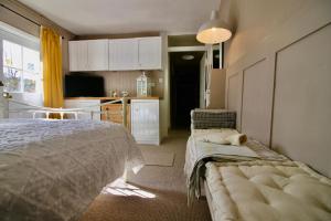 1 dormitorio con 1 cama y cocina con mesa en The Cottage at Barkwith House, en Leiston