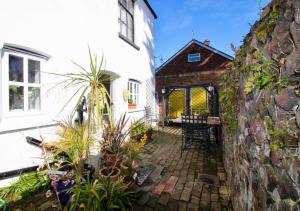 un patio de una casa blanca con plantas en The Cottage at Barkwith House en Leiston