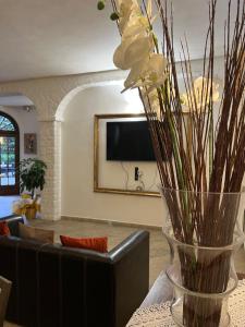 um vaso com flores brancas numa mesa numa sala de estar em Le Boccede Country House B&B em Villa Minozzo