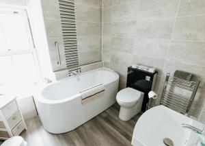 ein Badezimmer mit Badewanne, Toilette und Waschbecken in der Unterkunft WILLOW COTTAGE - Cost 3 Bed Cottage in Penrhyn Bay with Sea Views with Access to Snowdonia in Llandrillo-yn-Rhôs + 22 Fotos