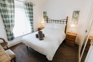 ein Schlafzimmer mit einem Bett und einem Fenster in der Unterkunft WILLOW COTTAGE - Cost 3 Bed Cottage in Penrhyn Bay with Sea Views with Access to Snowdonia in Llandrillo-yn-Rhôs