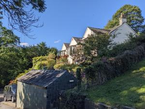 a house on a hill with a car parked in front at Three Peaks in Braithwaite