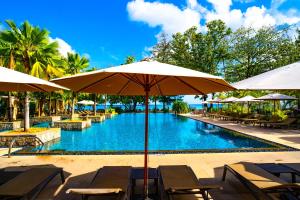 a pool with tables and umbrellas in front of it at STORY Seychelles in Beau Vallon