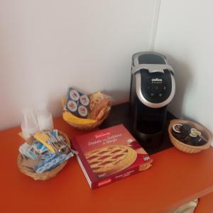 uma mesa com um processador de alimentos e um livro e snacks em B & B di Massimo C em Spotorno