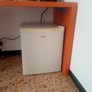 um pequeno frigorífico branco debaixo de uma secretária em B & B di Massimo C em Spotorno