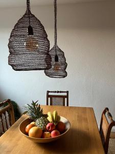 a bowl of fruit on a wooden table with two lights at Wanderlust East73 in Trier +14 photos