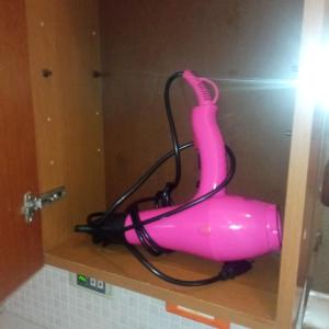 um secador rosa sentado em cima de uma prateleira em B & B di Massimo C em Spotorno