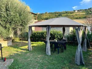 d'un kiosque avec une table et des chaises. dans l'établissement Lu Prete, à Campofilone