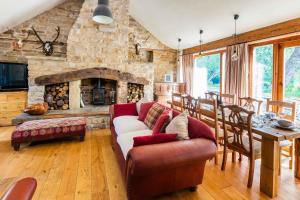 a living room with a couch and a stone fireplace at Bence Farm Yorkshire, barn conversion with hot tub karaoke great views between leeds and sheffield 
