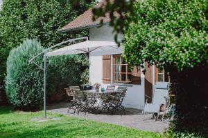 eine Terrasse mit einem Tisch und Stühlen unter einem Sonnenschirm in der Unterkunft Guggi`s Alm in Dirlewang