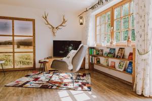 a living room with a chair and a book shelf at Guggi`s Alm in Dirlewang